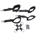 Two black adjustable wrist restraints with metal snap clasps, plus a leather cross-connector with four metal rings and a small accessory bag.
