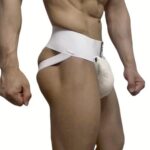 Male model wearing a white jockstrap athletic supporter with a pouch and wide waistband, shown in a side view with fists by his sides.