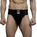 Man wearing a black jockstrap with a wide waistband and visible label at the front.