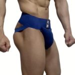 Muscular man wearing a blue, cut-out side athletic brief/jockstrap-style swimsuit viewed from the hip level