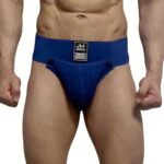Front view of a male model wearing navy blue briefs with a branded waistband tag showing JM JOCKMAIL on the front center.