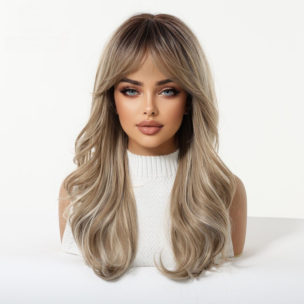 Bust portrait of a woman with long, wavy blonde hair and side-swept bangs against a light background, wearing a white knit top.