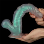 Flexible, curved silicone sex toy being held by two hands against a black background, designed for sexual wellness use.